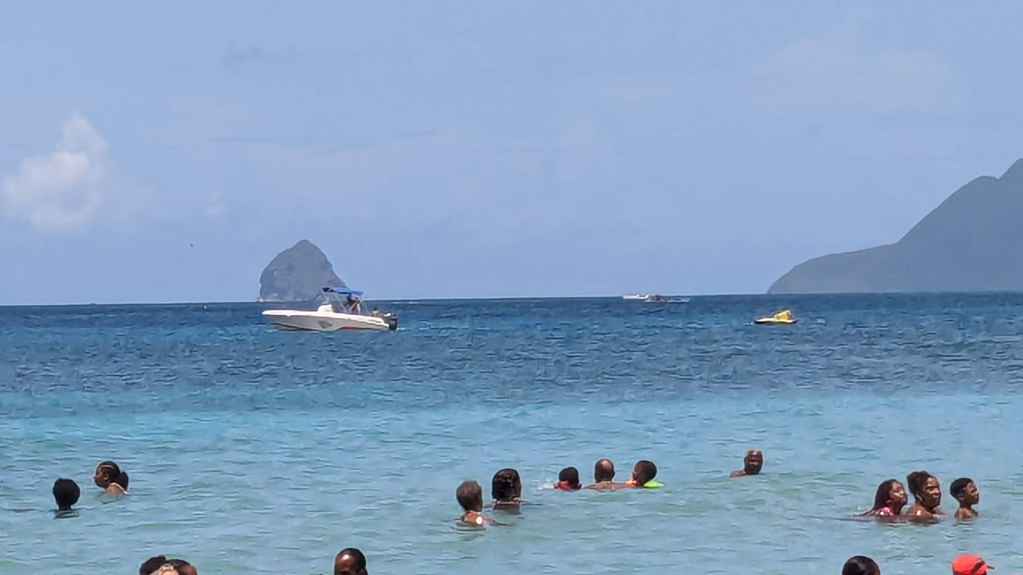 Photo de vacanciers dans la mer avec au loin rocher du diamant